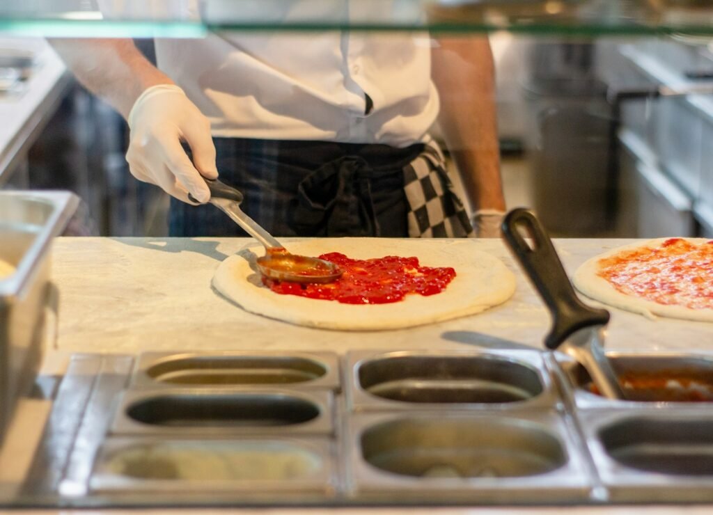 a chef is preparing pizzas in a kitchen